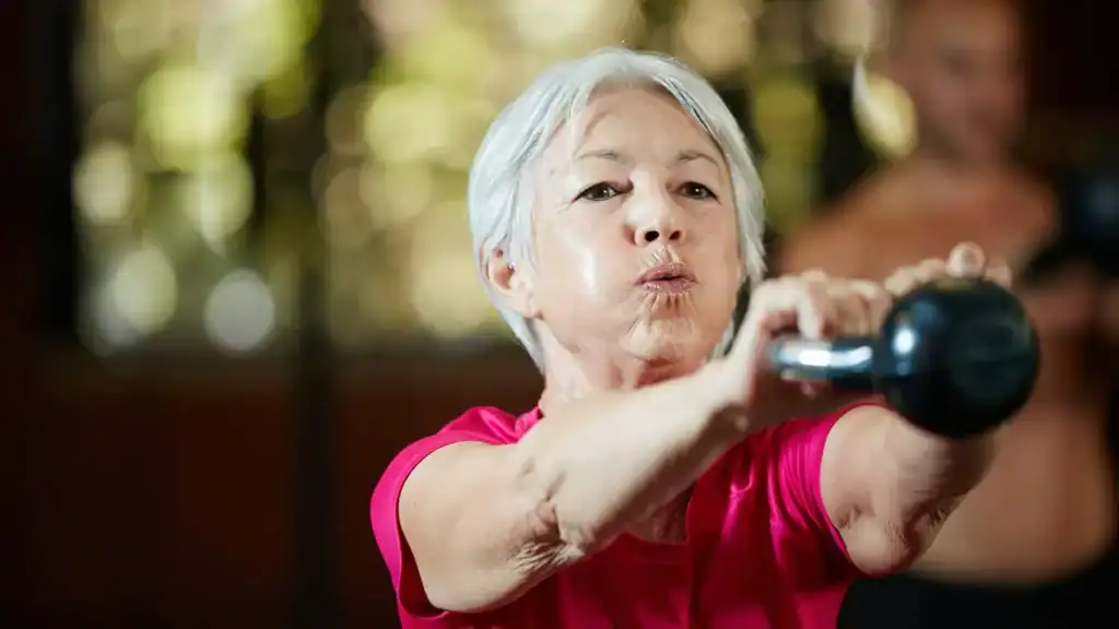 Older woman doing weight training Maidstone to help her strength and longevity 