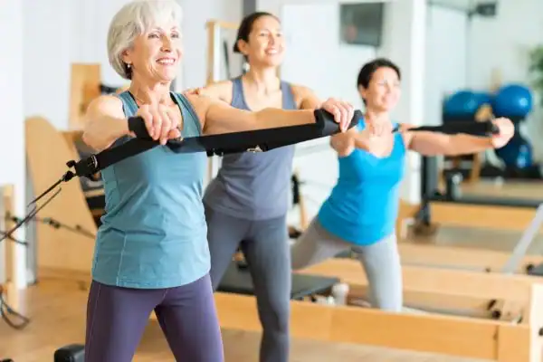 Toning Arms After 60: Empowering Womens Fitness Through Effective Weight Training 2 older woman doing weight training Maidstone and resistance in the gym to tone upper arms